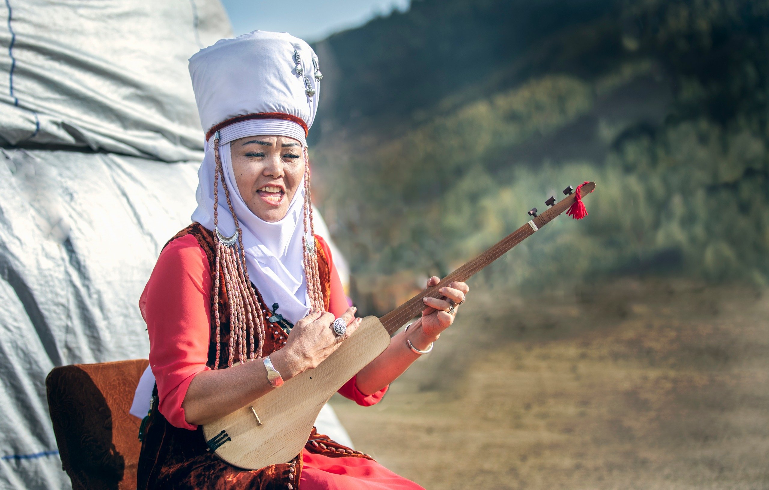 Киргиз поет. Комуз киргизский. Киргизский музыкальный инструмент. Киргизские народные музыкальные инструменты. Девушка с домброй.