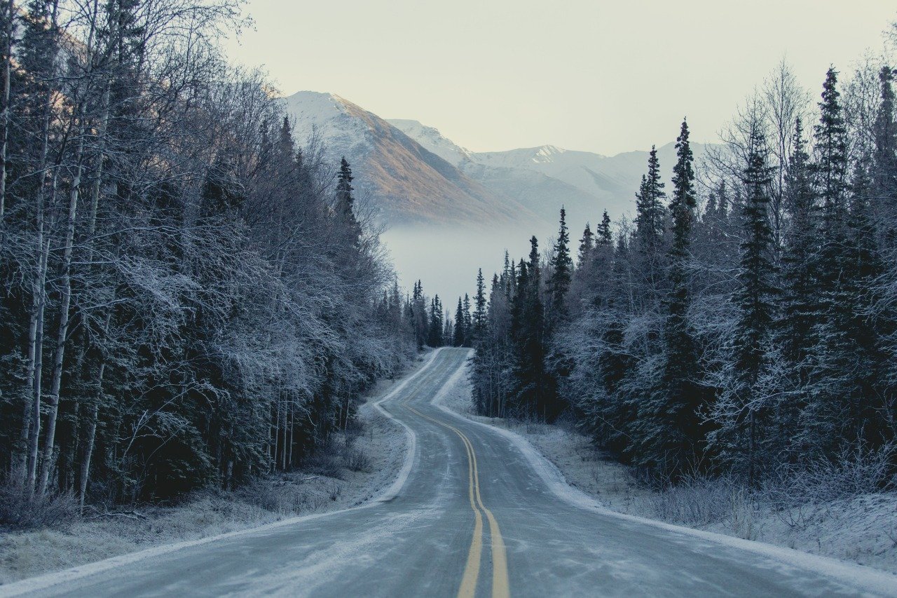 Тема зимней дороги. Зимняя дорога. Заснеженная дорога в лесу. Снег на дороге. Дорога в гору.